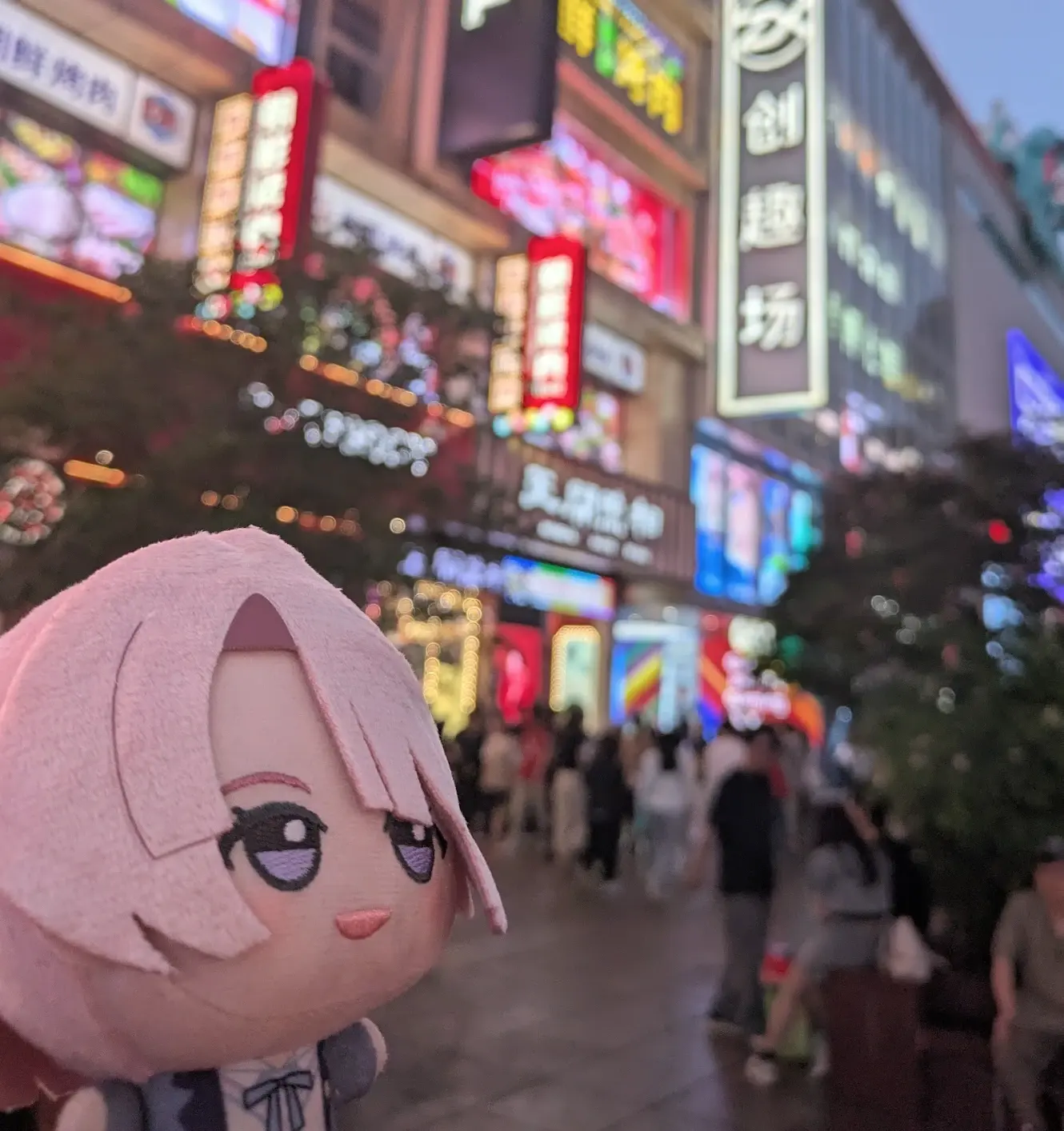 夜の繁華街とちびぐるみ
